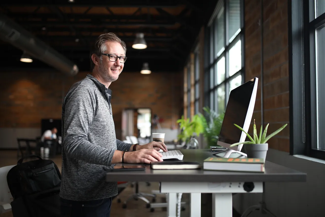 Small business owner working at a standing desk in a bright office