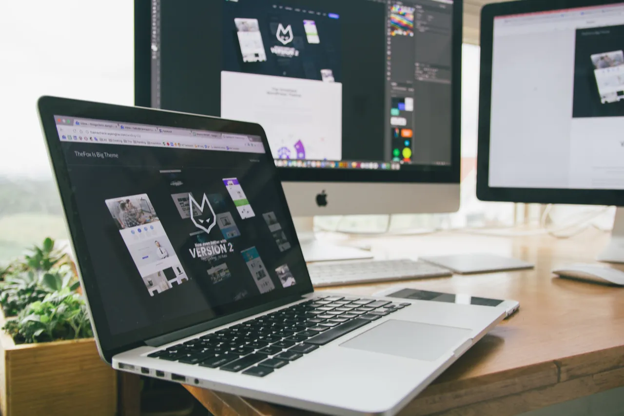 Laptop and desktop displaying a React web application under development